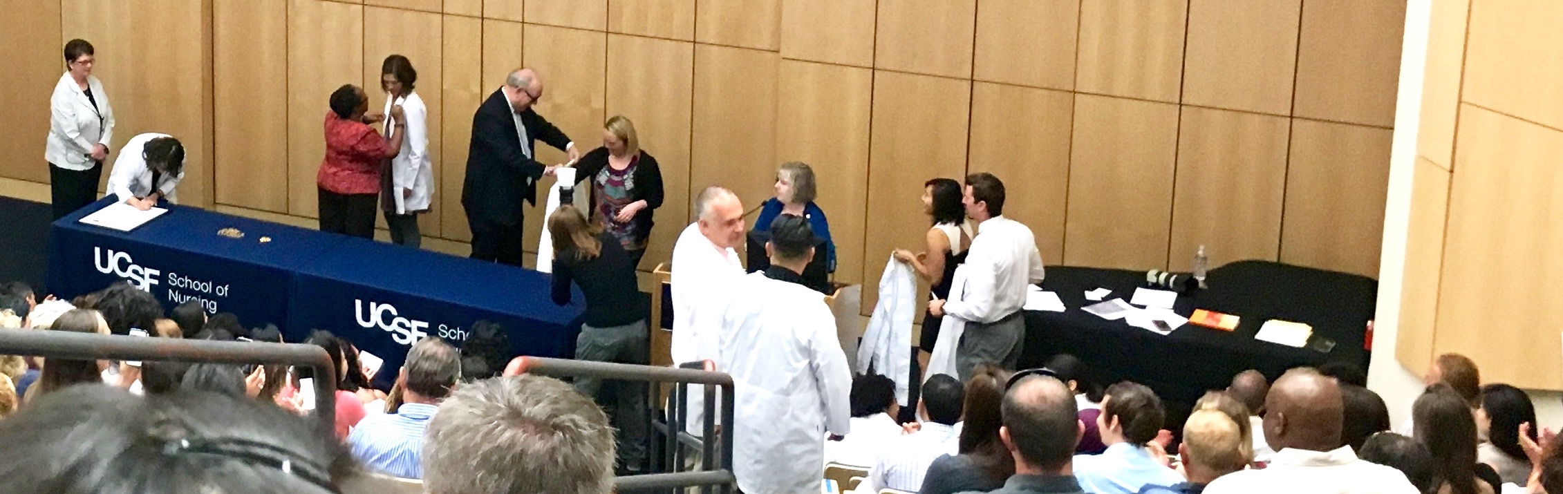 2016 MEPN students approach the podium and stage to receive their white coats and pins.