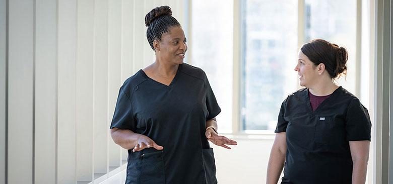 PMHNP student Janet Meda, left, speaks with her preceptor Ann Marie Coria, who is a PMHNP at UC Davis Health. The UCSF, UC Davis and UCLA schools of nursing have partnered to prepare 300 PMHNPs within a five-year period.