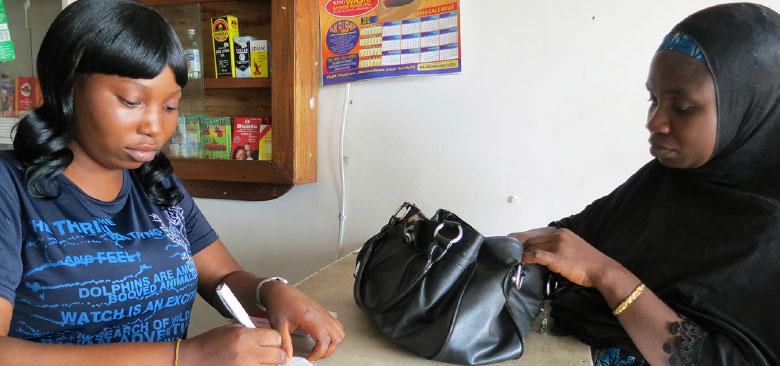 A drug shop worker counsels a customer (photo by Anna de la Cruz).