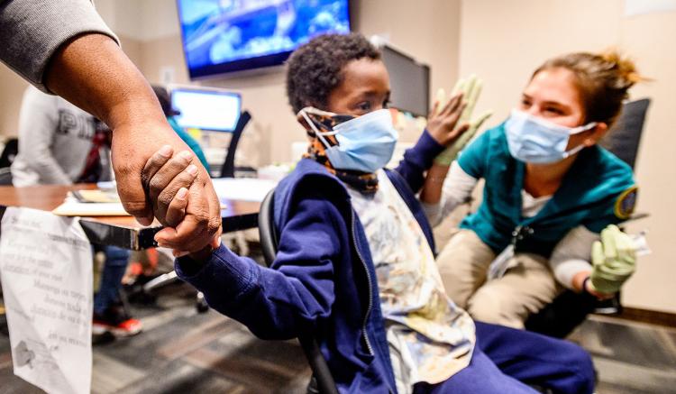 UCSF School of Nursing MEPN student Kalmia Beets administers a COVID-19 vaccine to Ezekiel Finley, 7, at UCSF Benioff Children's Hospital Oakland on Dec. 11, 2021. (Photo by Noah Berger)