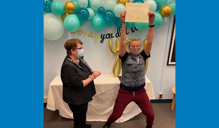 Caycee Cullen holds her MEPN certificate as MEPN Interim Director Mary Foley applauds.