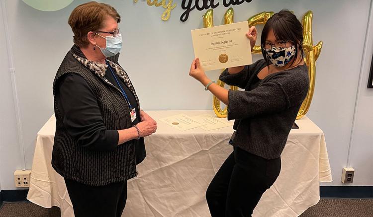 Debbie Nguyen receives her pin and certificate from MEPN Interim Director Mary Foley.