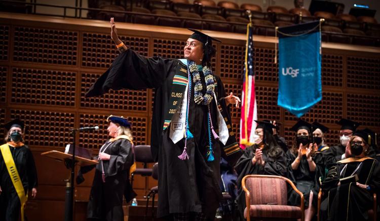 Vicky Valentine, a master's graduate, waves to family and friends as she crosses the stage.