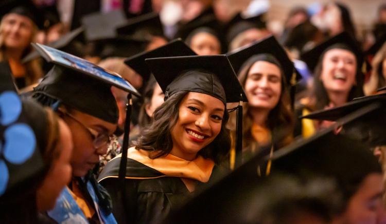 Maritza Franqui, a master's graduate, sits with classmates at Commencement.