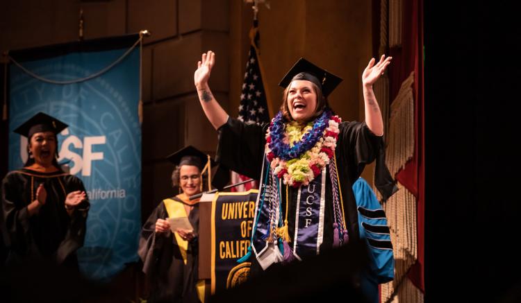 Sachi Timmons, a master's graduate, takes a celebratory walk across the stage at Commencement.