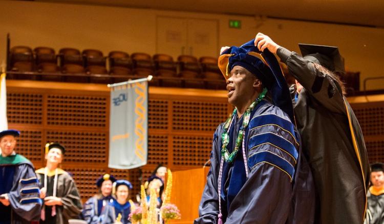 Austin Nation receives his doctoral hood from our faculty, congratulations!