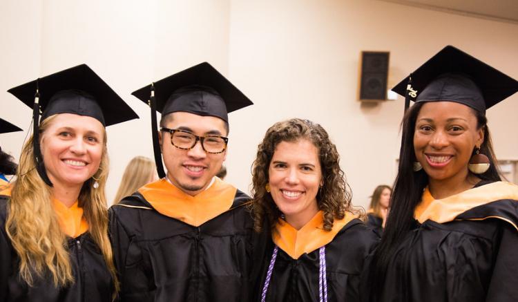 Group of students pose at 2016 commencement ceremony.