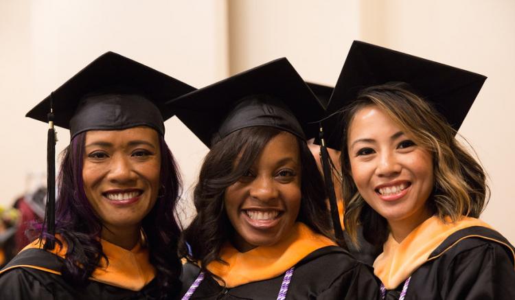 Group of students pose at 2016 commencement ceremony.