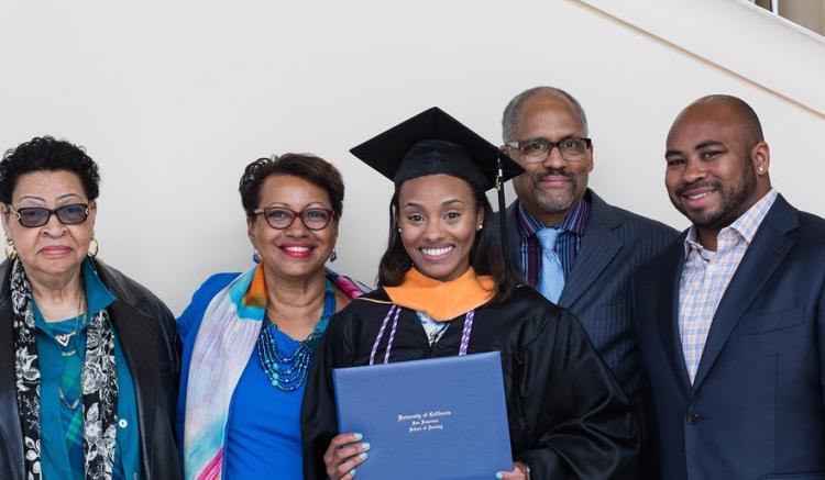 2016 grad poses with her family following commencement.