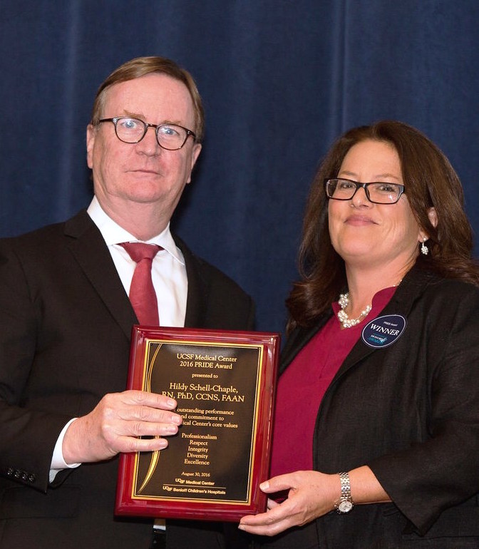 UCSF Chancellor Sam Hawgood presents Volunteer Faculty Hildy Schell-Chaple, RN, PhD, CCNS, FAAN, with 2016 UCSF Medical Center PRIDE Award