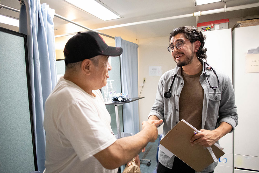 Frank Molina supports a client at the Homeless Clinic