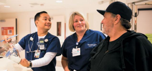 Jim Banta (right) discusses his time as a patient with UCSF Medical Center nurses Jeselle Abilla and Kristina Haas (photo by Elisabeth Fall).