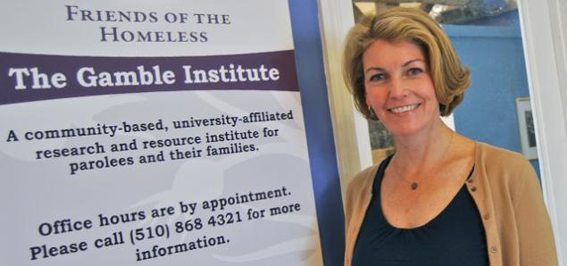 Elizabeth Marlow stands next to a sign for the The Gamble Institute.