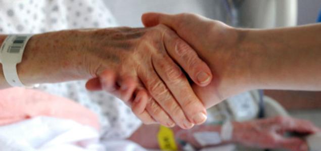 A patient shakes the hand of a health care provider.