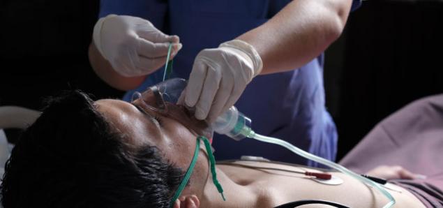 A nurse applies a manual pump CPR resuscitation Ambu bag on a patient