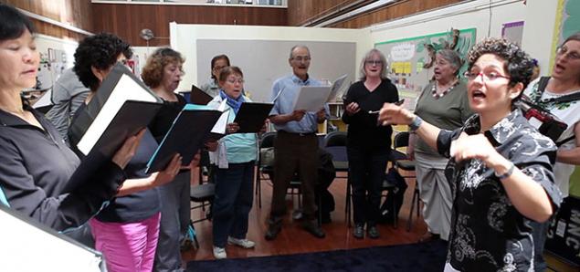 A choir of seniors at San Francisco’s Mission Neighborhood Centers is led by Community of Voices Choir conductor Martha Rodriguez-Salazar (still from video by Elisabeth Fall).