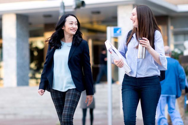 Cherry Leung smiling and walking with a student. 