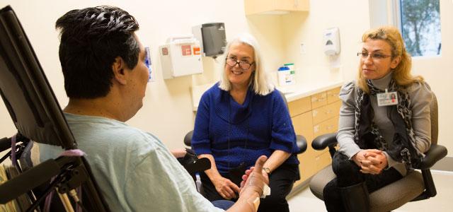 Anne Hughes (center) and student Julia Itsikson (right) consult with a patient at Laguna Honda Hospital and Rehabilitation Center in San Francisco (photo by Elisabeth Fall). 