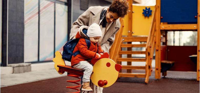 Adult helps a child on the playground