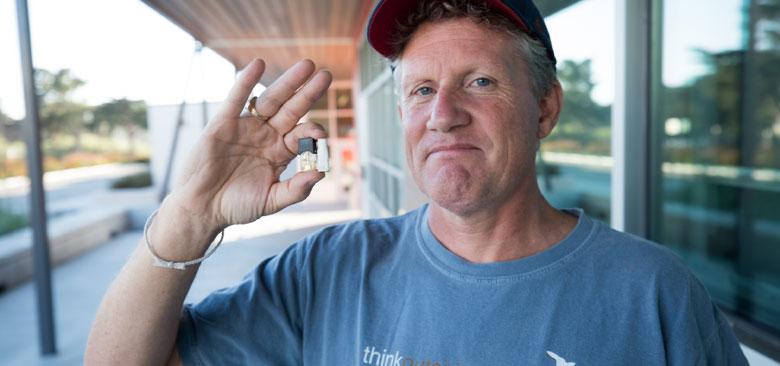 UCSF associate professor Jeremiah Mock holding a JUUL e-cigarette cartridge and a cigarette butt he found on a local high school campus (photo by Elisabeth Fall) 