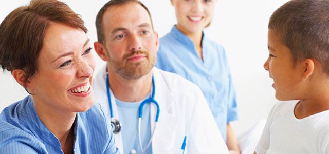 Three health care providers speak with a patient.