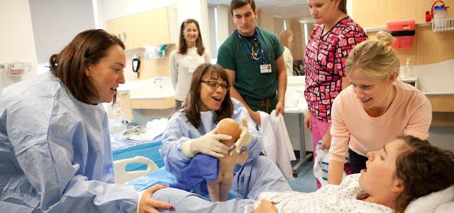 Students practice delivery both with “standardized patients” (live actors), as shown above at San Francisco General Hospital, and with robotic “simulated patients” at UCSF’s Kanbar Center, pictured in the linked slideshow (photos by Elisabeth Fall).