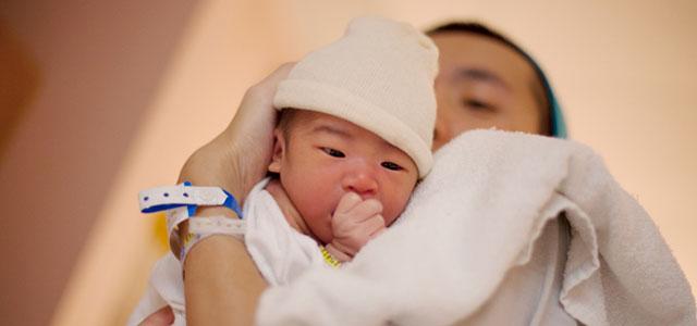 Parent holds newborn baby. 