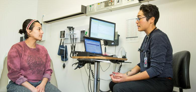 Nurse practitioner resident Haruka Kelley (right) with a patient at the VA women’s clinic. (Photos by Elisabeth Fall.)