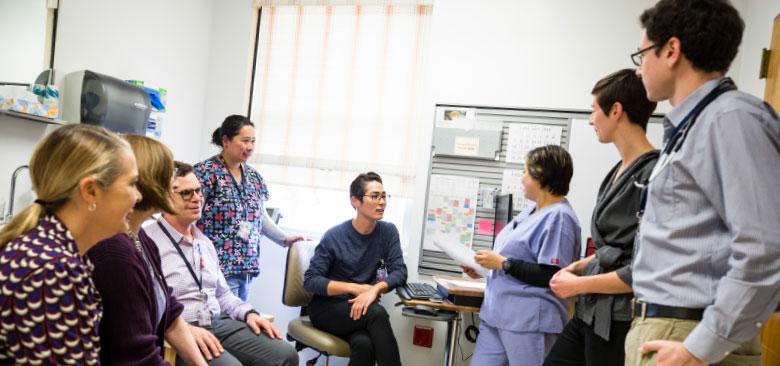 An EdPACT team engages in a morning huddle. From left to right: Co-director Rebecca Shunk, faculty member JoAnne Saxe, psychiatric/mental health nurse practitioner James Caldwell, registered nurse Cora Aquino, nurse practitioner resident Haruka Kelley, licensed vocational nurse Marbing Pablico, Co-director Anna Strewler and physician resident Max Brondfield. (Photos by Elisabeth Fall.)