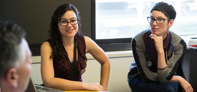 Veronica Ramirez (center) and master’s student Sarah Beth Bailey with a patient at the East Bay AIDS Center (photos by Elisabeth Fall)