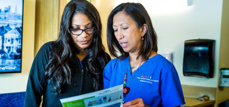 Barbette Murphy (right) introduces a patient/parent educational brochure about preventing falls to Hospital Unit Service Coordinator Yolanda Jackson (photos by Elisabeth Fall).