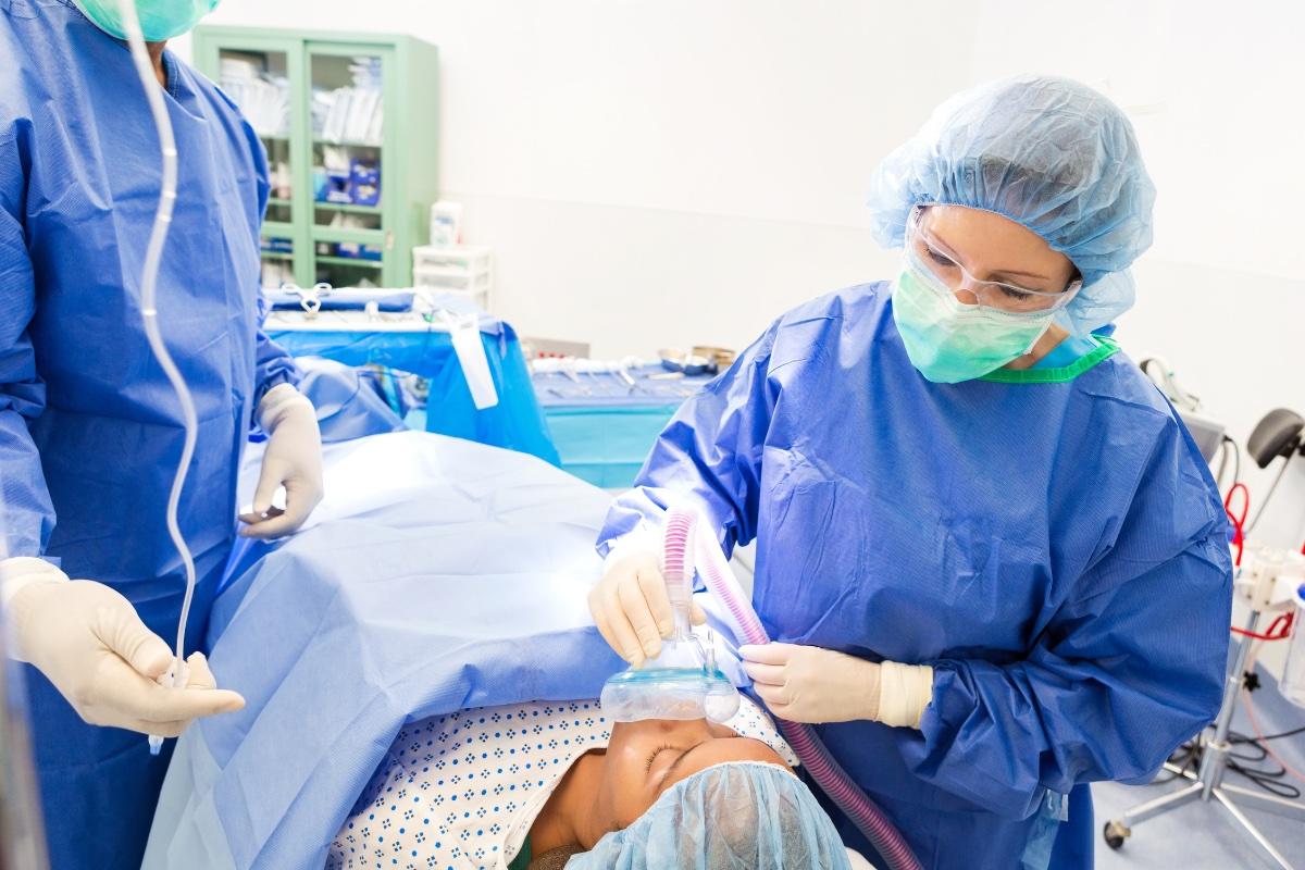 CRNA provides anesthesia to a patient in a surgery room