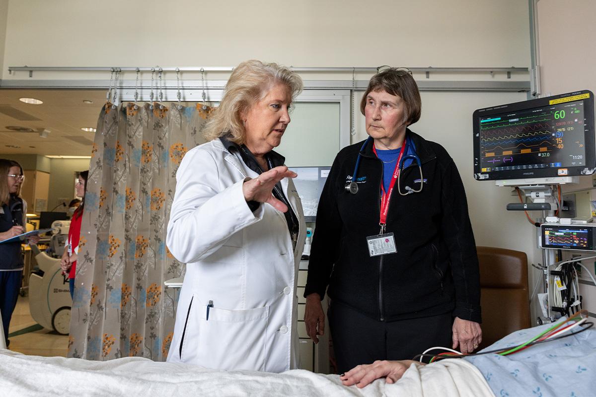 Michele Pelter, PhD, RN, speaks to Kirsten Fleischmann, MD, MPH, and a patient from a hospital room in the cardiac ICU. 