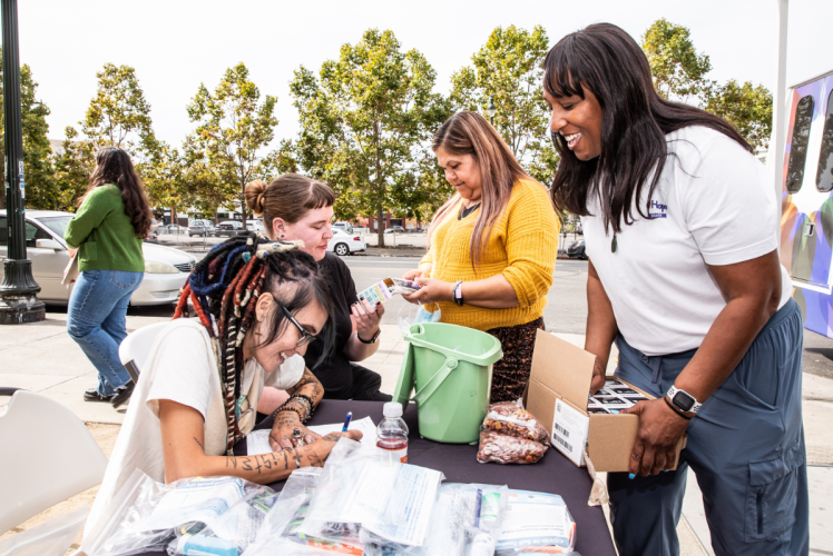 Natalie Wilson, DNP, PhD, MPH, assistant professor (far right), members of the HOPE Mobile Clinic and community partners provide health care services and hygiene kits in downtown Oakland, California (photo credit: Elisabeth Fall).