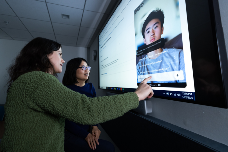 Two people look at screen