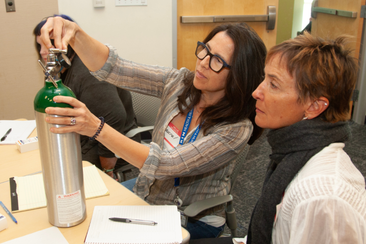 Two nurses check oxygen levels