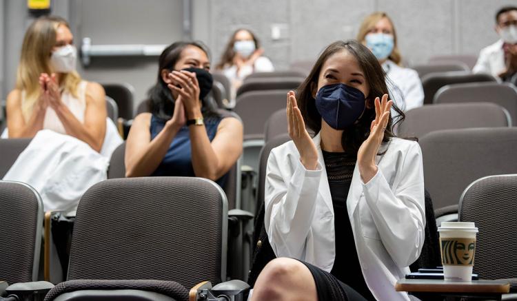 Student Cassie Xu applauds her peers at the MEPN Pinning Celebration.