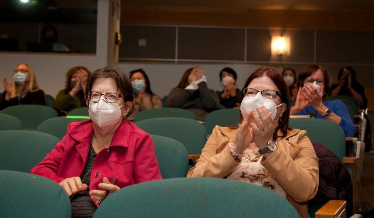 Associate professor Teri Lindgren, right, applauds as Carol Dawson-Rose delivers her lecture.