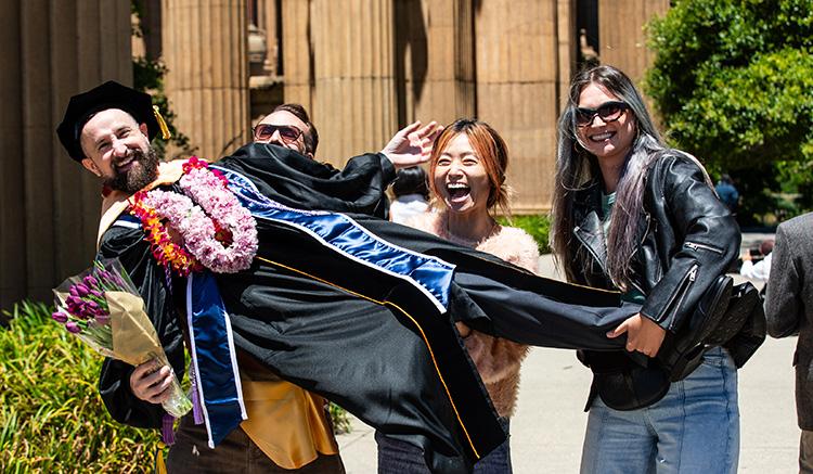 Joshua Munday celebrates with loved ones at the 2026 UCSF School of Nursing Commencement at the Palace of Fine Arts. 