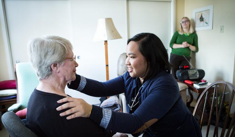 Assistant Professor Laura Wagner (far right) observes AGNP student Nhat Bui examining resident Margaret Jacobs at San Francisco’