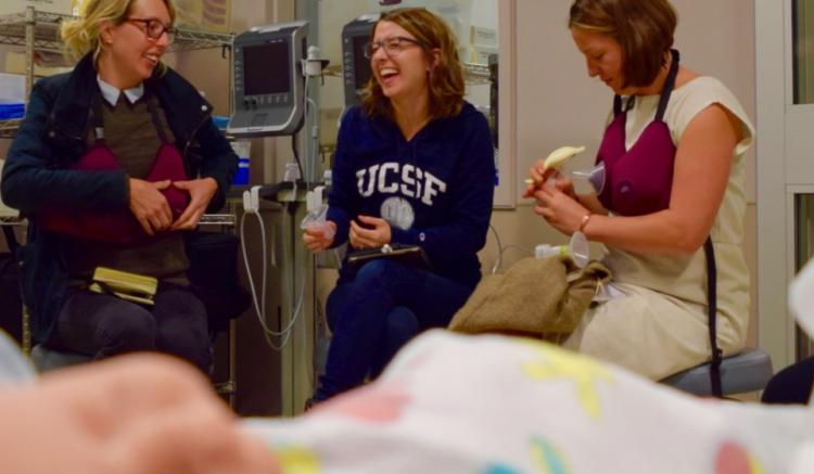 Three midwifery students and volunteers demonstrate with equipment