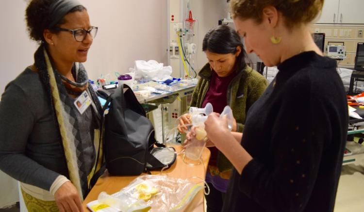 Three midwifery students and volunteers demonstrate with equipment