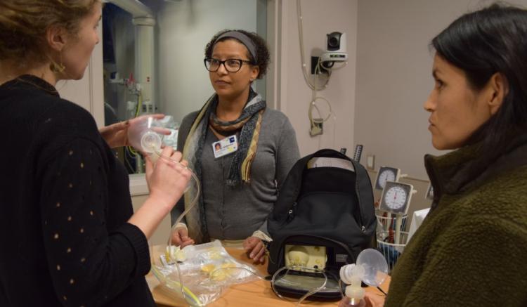 Three midwifery students and volunteers demonstrate with equipment