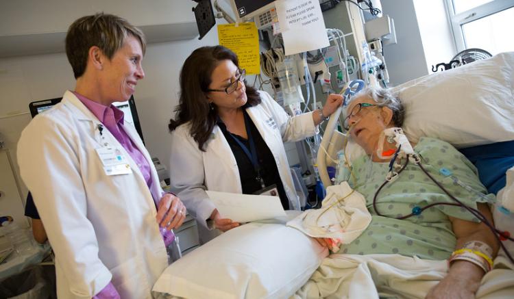 Photo credit Elisabeth Fall. Two nurses look after a patient
