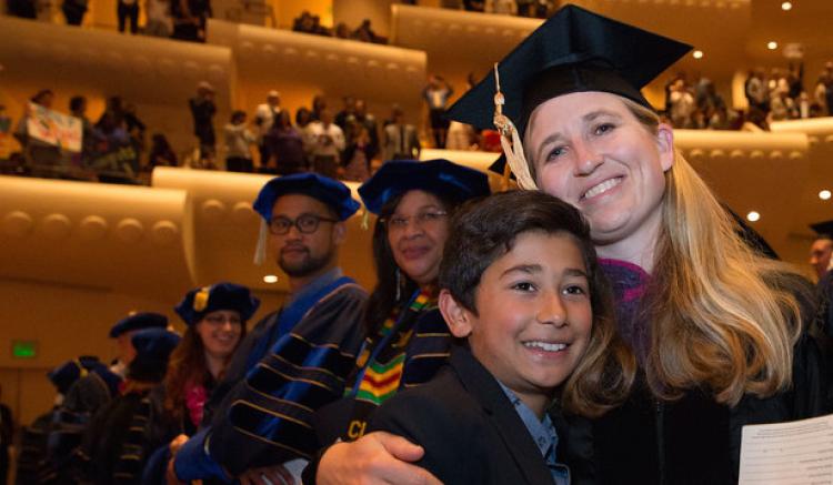graduate embraces child