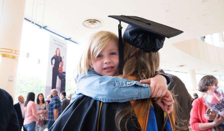 child in graduate arms