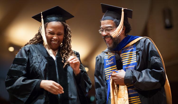 graduate and faculty share a laugh