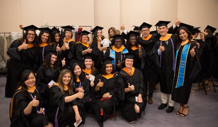 Group of students pose at 2016 commencement ceremony.