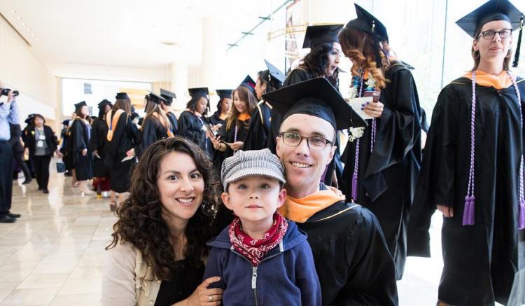 2016 grad poses with family following commencement.