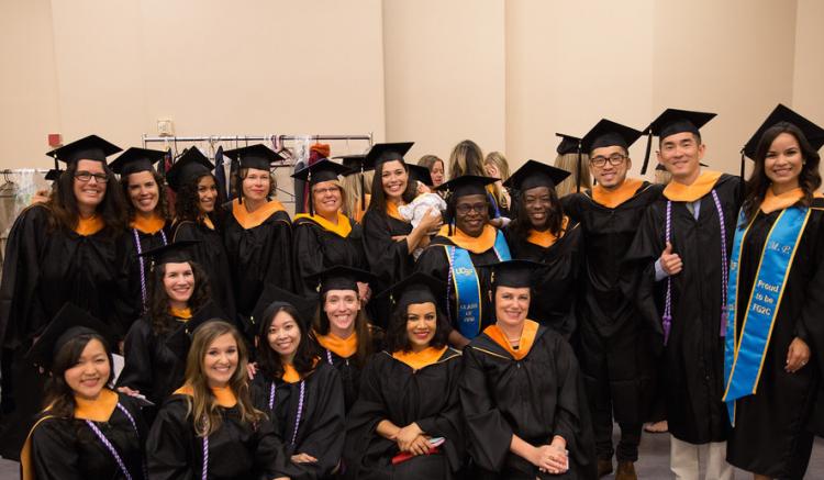 Group of students pose at 2016 commencement ceremony.